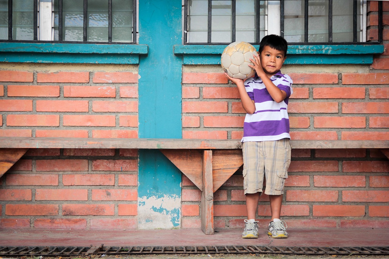 Young soccer player holding a ball