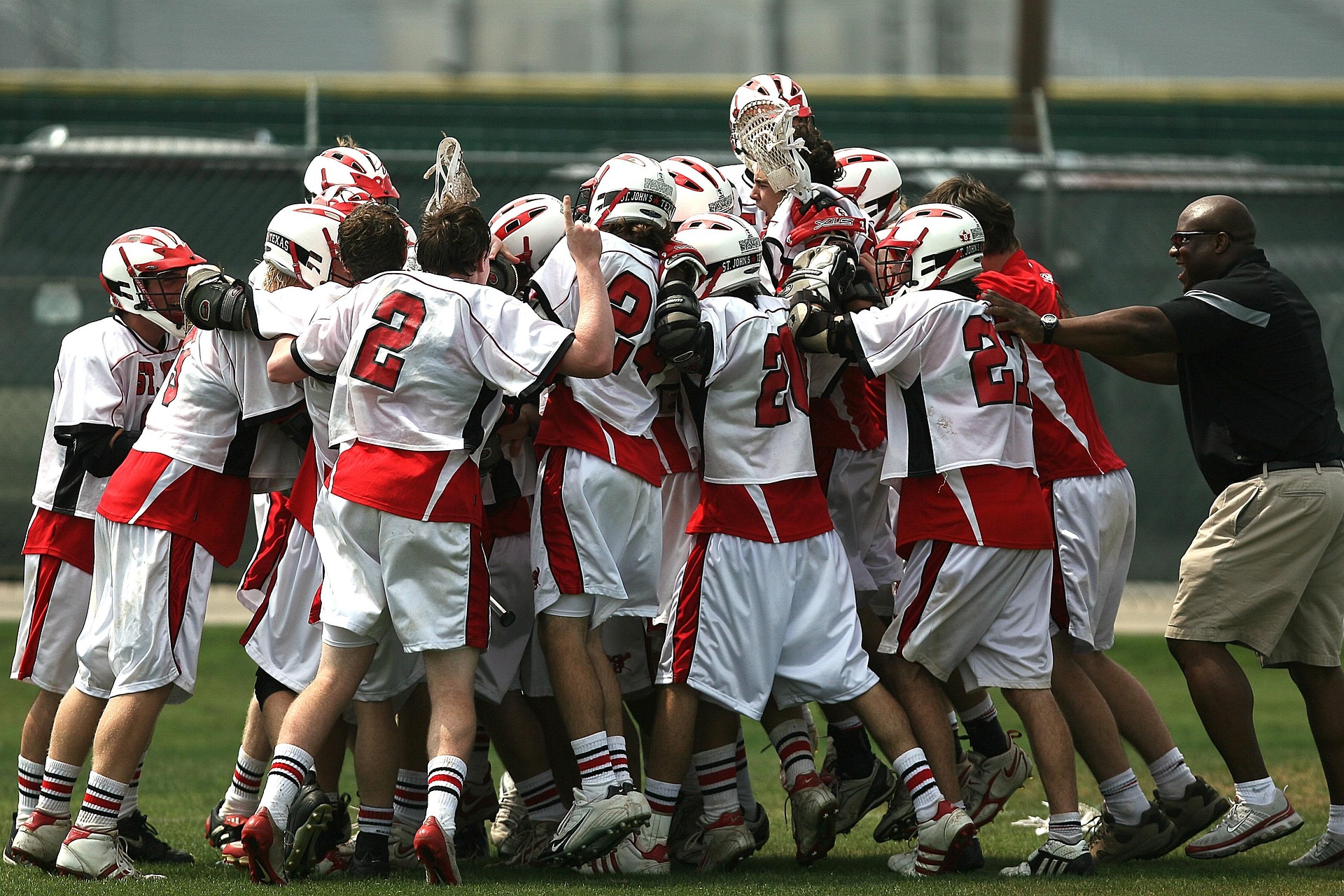 Coach supporting youth lacrosse players during practice
