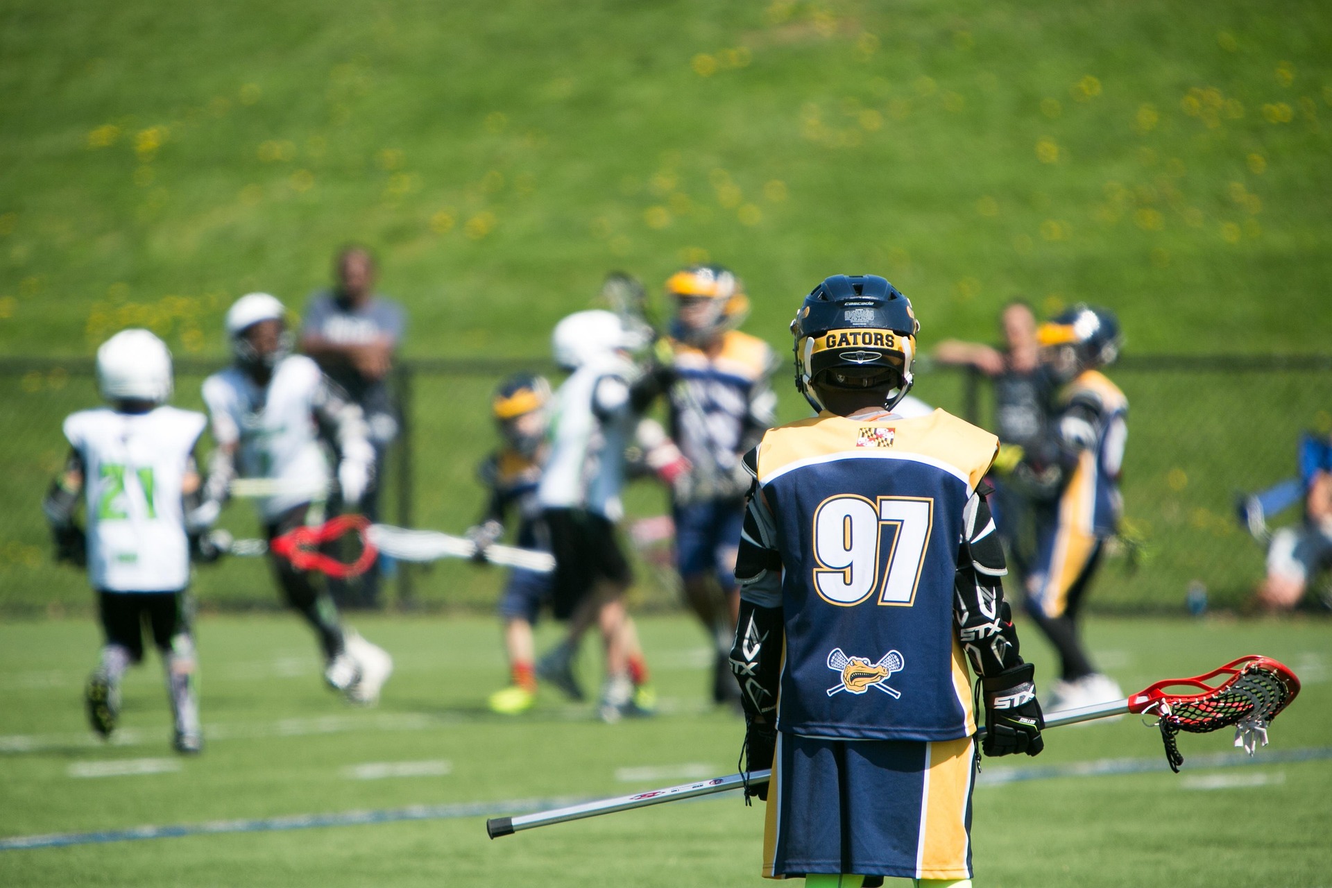 Lacrosse youth athletes practicing with coach guidance