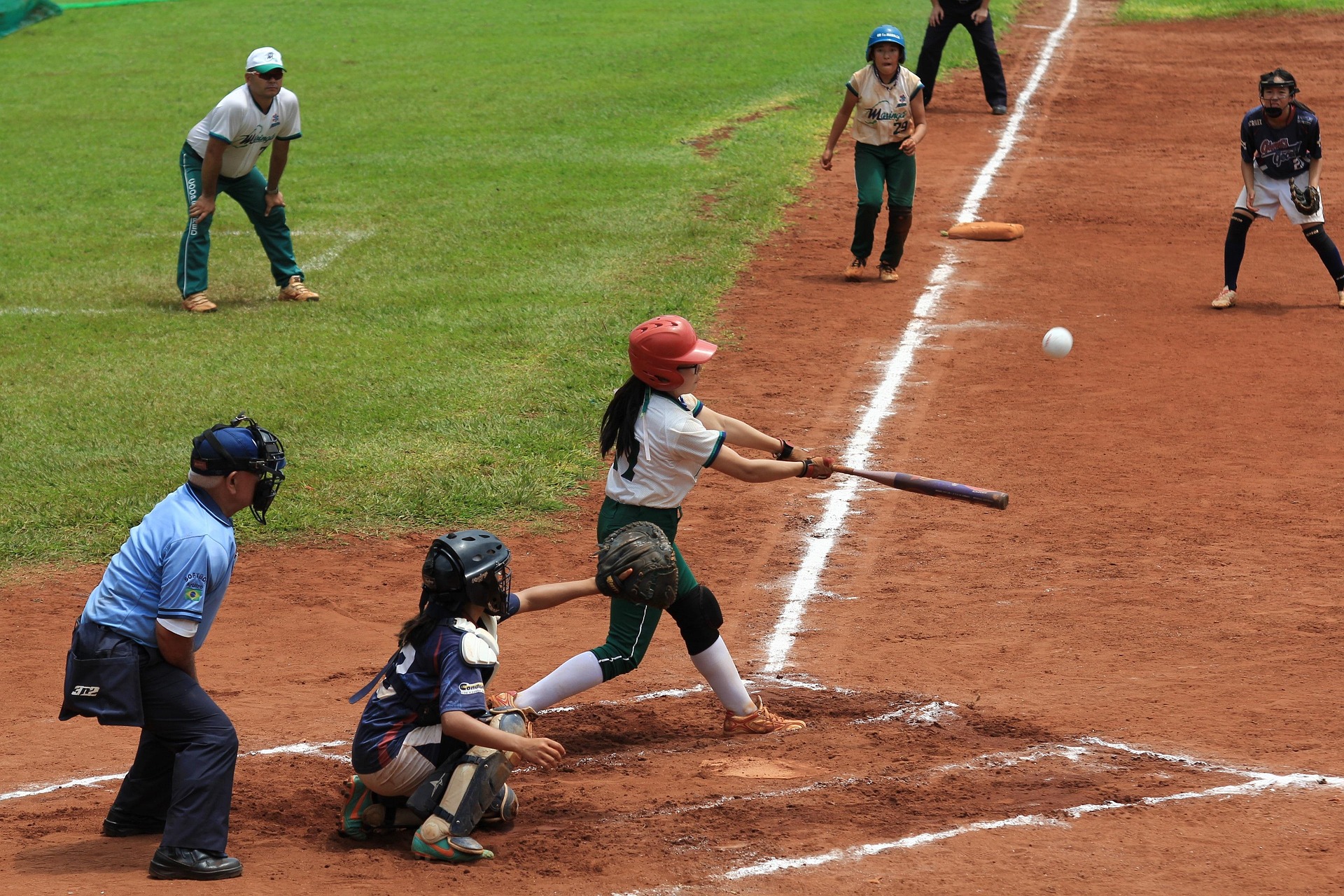 Softball youth athletes practicing with coach guidance