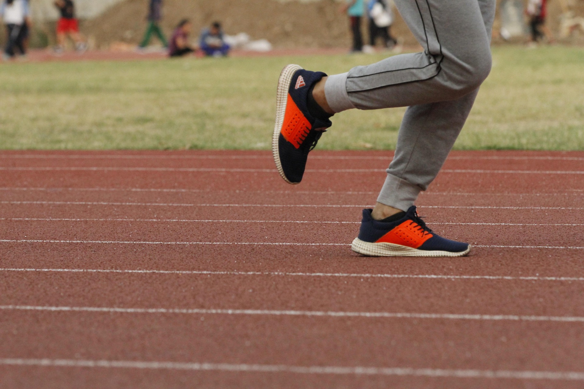 Coach supporting youth track and field players during practice
